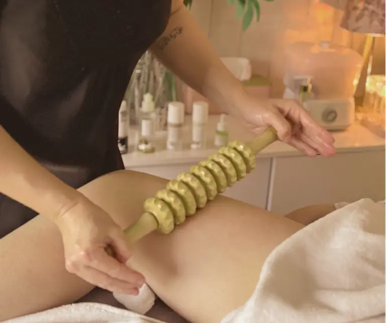 massage drainant avec un rouleau en bois